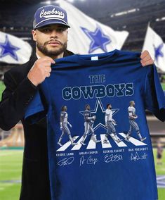 a man holding up a t - shirt with the cowboys on it