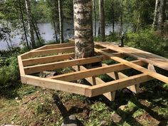 a wooden structure sitting next to a tree in the woods