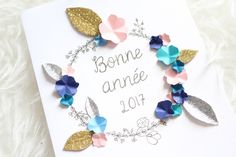 a card with some flowers on it and the words bonne anne written in silver