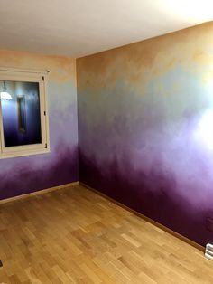 an empty room with purple and yellow paint on the walls