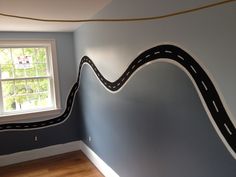 a room with a wall painted to look like a road going up the side of it