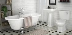 a white bath tub sitting next to a toilet and sink in a bathroom with black and white tile flooring