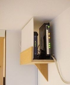 there is a small shelf with a router on it and wires attached to the wall