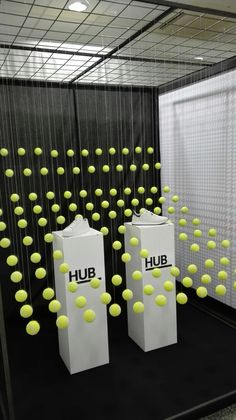 two white boxes with yellow tennis balls floating in the air next to eachother