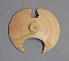 a wooden object with a circular hole in the middle on a gray surface and white background