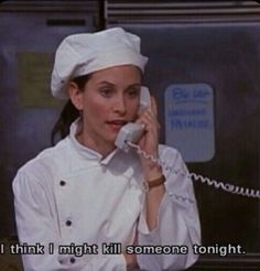 a woman talking on a phone while wearing a chef's hat