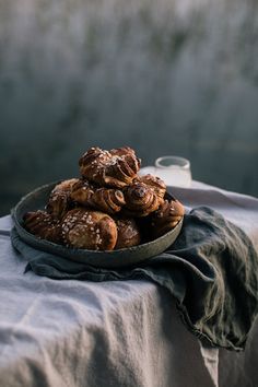 a plate filled with pastries on top of a blue table cloth next to a cup