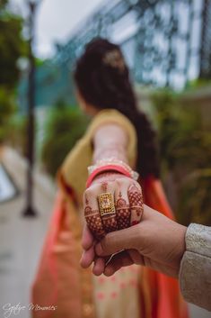 a woman holding out her hand with henna on it