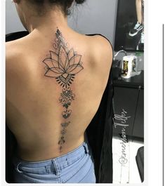 the back of a woman's neck with tattoos on it