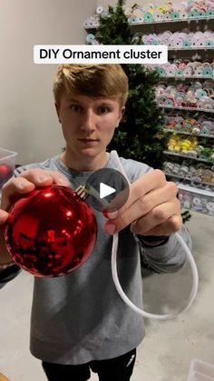 a young man holding a red ornament in his hand