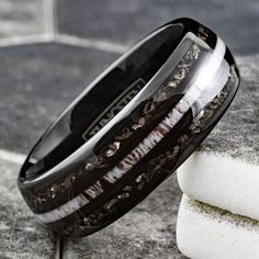 a close up of a wedding ring on top of two pieces of white and black marble