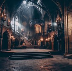 the inside of an old building with stairs and chandeliers lit up at night