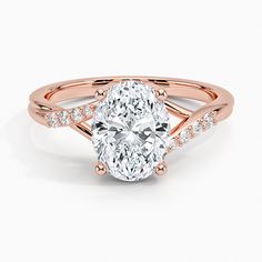 a rose gold ring with a oval cut diamond in the center and side stones on each band