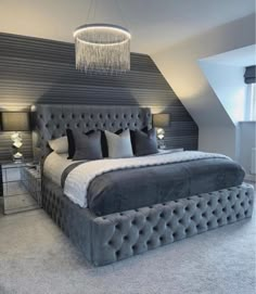 a large bed sitting under a chandelier in a bedroom