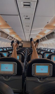 a woman's legs are seen on the back of an airplane with empty seats