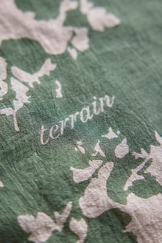 a close up of a green and white flowered shirt with the words teatroin printed on it