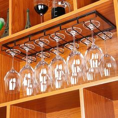 wine glasses are lined up on a shelf