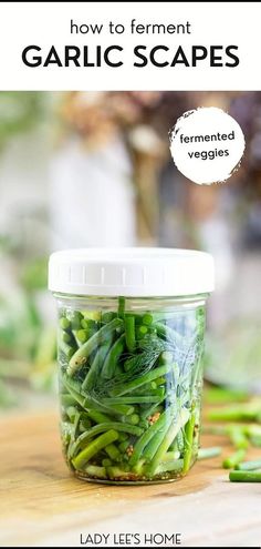 a jar filled with green beans sitting on top of a wooden table