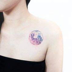 a woman with a tattoo on her chest has a pink moon in the middle of it