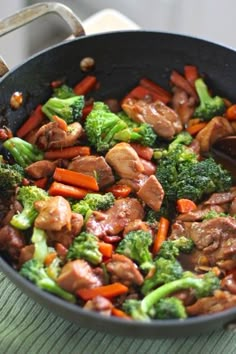 broccoli, carrots and meat are being cooked in a skillet