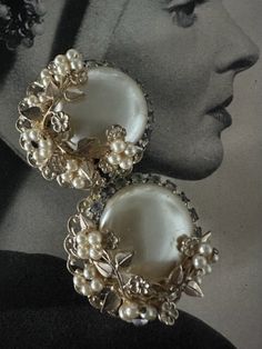 "Vintage Stunning Mega Pearl Button Earrings with Ornate gold Leaves , Vines and Faux Pearl Flowers with Rhinestones. They measure 1 3/8\" in diameter. The back is a gold metal filagree . They are clip ons and they function well. The rhinestones that are round one side of the button pearl are a smokey clear color. These earrings are rare and absolutely gorgeous. They may be an early unmarked Miriam Haskell.  Free Shipping in the U.S. when Purchasing $35 or more. Complementary Vintage Gift Wrap o 1950s Accessories, Button Pearl Earrings, 1950s Jewelry Style, Vintage Pearl Earrings, 1940s Jewelry, 2024 Wardrobe, Mid Century Earrings, 1950s Jewelry, Pearl Flowers