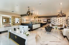 the interior of a nail salon with white and black chairs, chandeliers, and marble counter tops