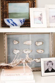 the shelf is filled with pictures and seashells on it's sides, along with two framed photographs