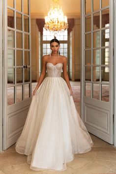 a woman in a wedding dress is walking into an open door with her hands on her hips