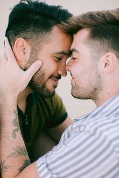 two men who are touching each other's foreheads and looking at each other