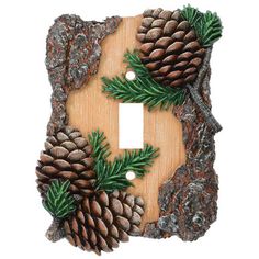 a light switch cover with pine cones and needles