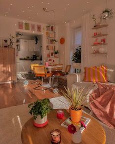 a living room filled with furniture and lots of plants on top of a wooden table