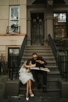 a man and woman sitting on the steps of a building