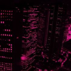 an aerial view of the city at night with pink lights and skyscrapers in the background