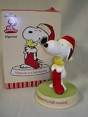 a snoopy figurine is next to a christmas card and it's box