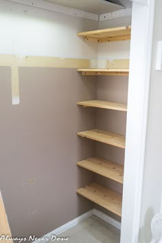 empty shelves in the corner of a room with no furniture or walls on either side