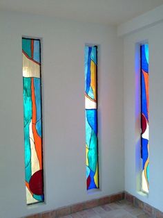 three stained glass windows in a white room