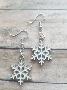 Adorable Christmas earrings ready for you to flaunt! The earrings are adorable, light weight and created of silvertone plated precious metals, with enamel white snowflake charms.  The earrings are recommended for ages 12 and older. The earrings are ready to be shipped.  Length: 2 inches Width: .75 inches Purchases will be shipped within 3-5 business days, unless requested otherwise.  Packages are shipped via USPS first-class mail. Once your order has been transported to the post office, a confir Holiday Winter Drop Earrings, Winter Holiday Drop Earrings, White Festive Earrings For Winter, Festive White Earrings For Winter, Nickel-free White Earrings For Christmas, White Snowflake Earrings For Christmas, White Snowflake Earrings For Gift, White Snowflake Earrings For Winter, Snowflake Earrings For Winter Gift