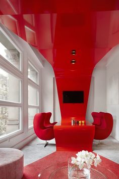 a living room with red furniture and large windows