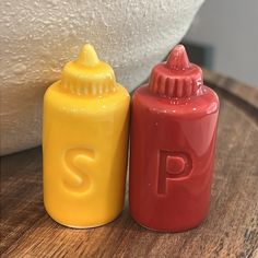 two plastic baby bottles sitting on top of a wooden table