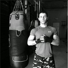 a man standing next to a punching bag