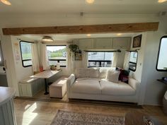 a living room filled with furniture next to a kitchen and dining area in a mobile home