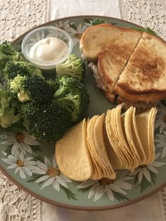 a plate with some bread, broccoli and other food on it