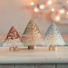 three small christmas trees sitting on top of a counter