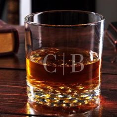 a glass filled with liquid sitting on top of a wooden table