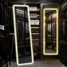 an illuminated mirror is in the middle of a walk - in closet