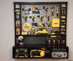 a black shelf filled with tools on top of a white wall next to a yellow toolbox