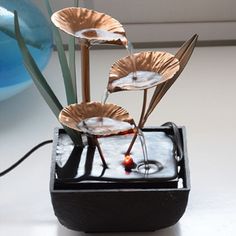 three water lilies in a black container on a table