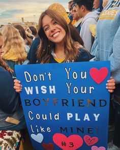 a girl holding a sign that says don't you wish your boyfriend could play like mine