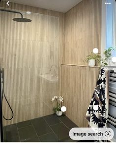 a bathroom with a shower, sink and towel hanging on the rack in front of it