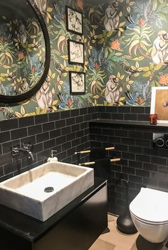 a bathroom with a sink, toilet and mirror in the wall next to it's tiled walls